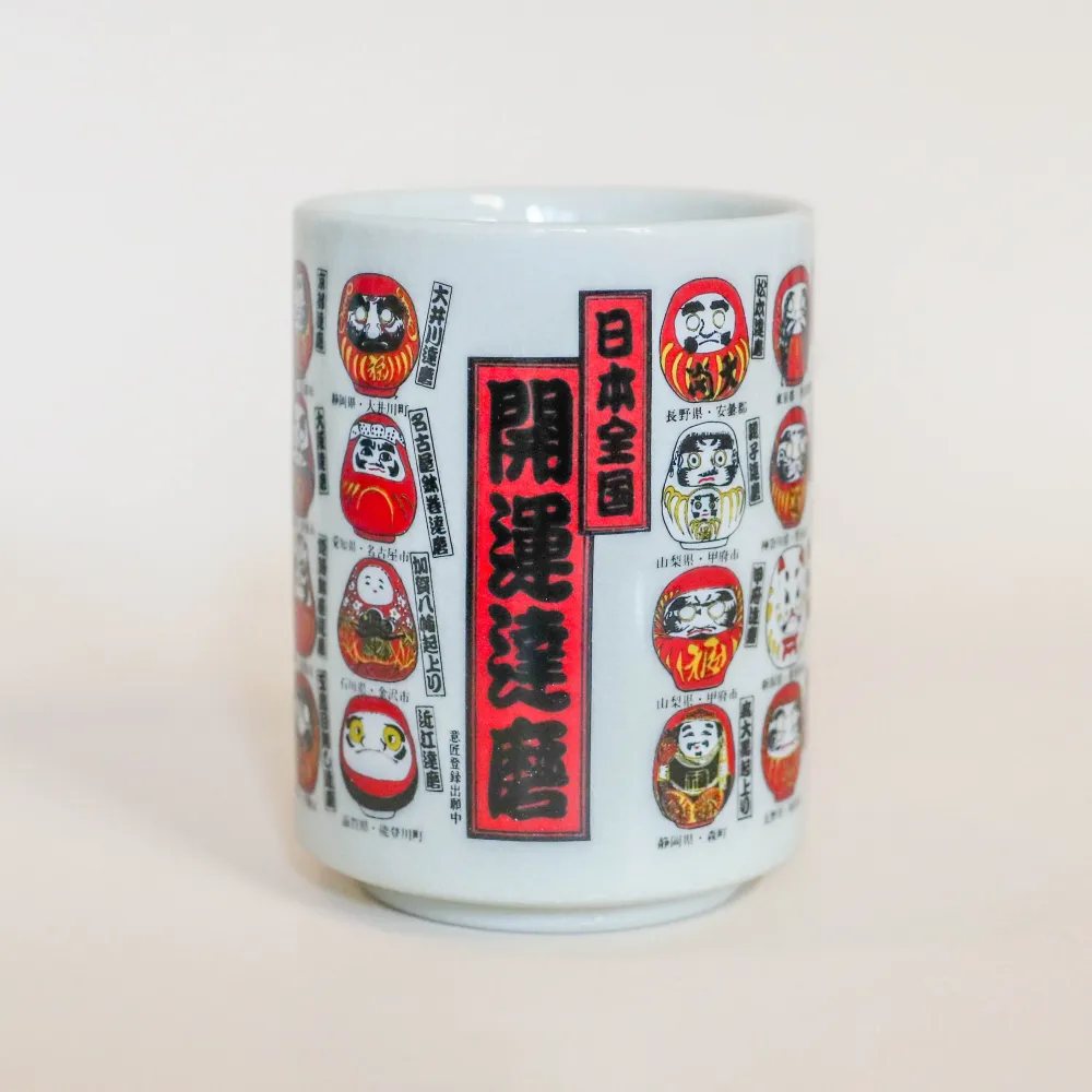 Kop med små daruma-figurer med forskellige udformninger